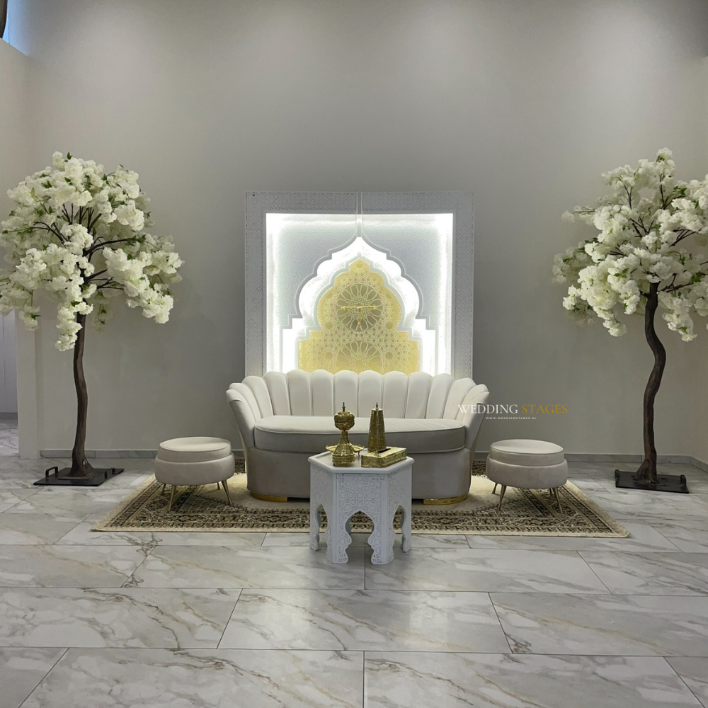 Elegant bruiloftsdecor met sofa en bloemen.