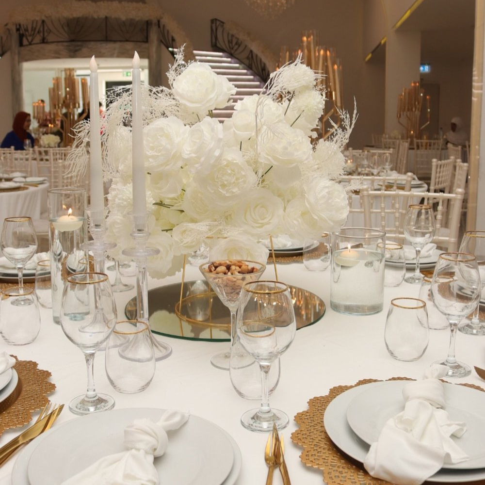Elegante tafelsetting met witte bloemen en kaarsen