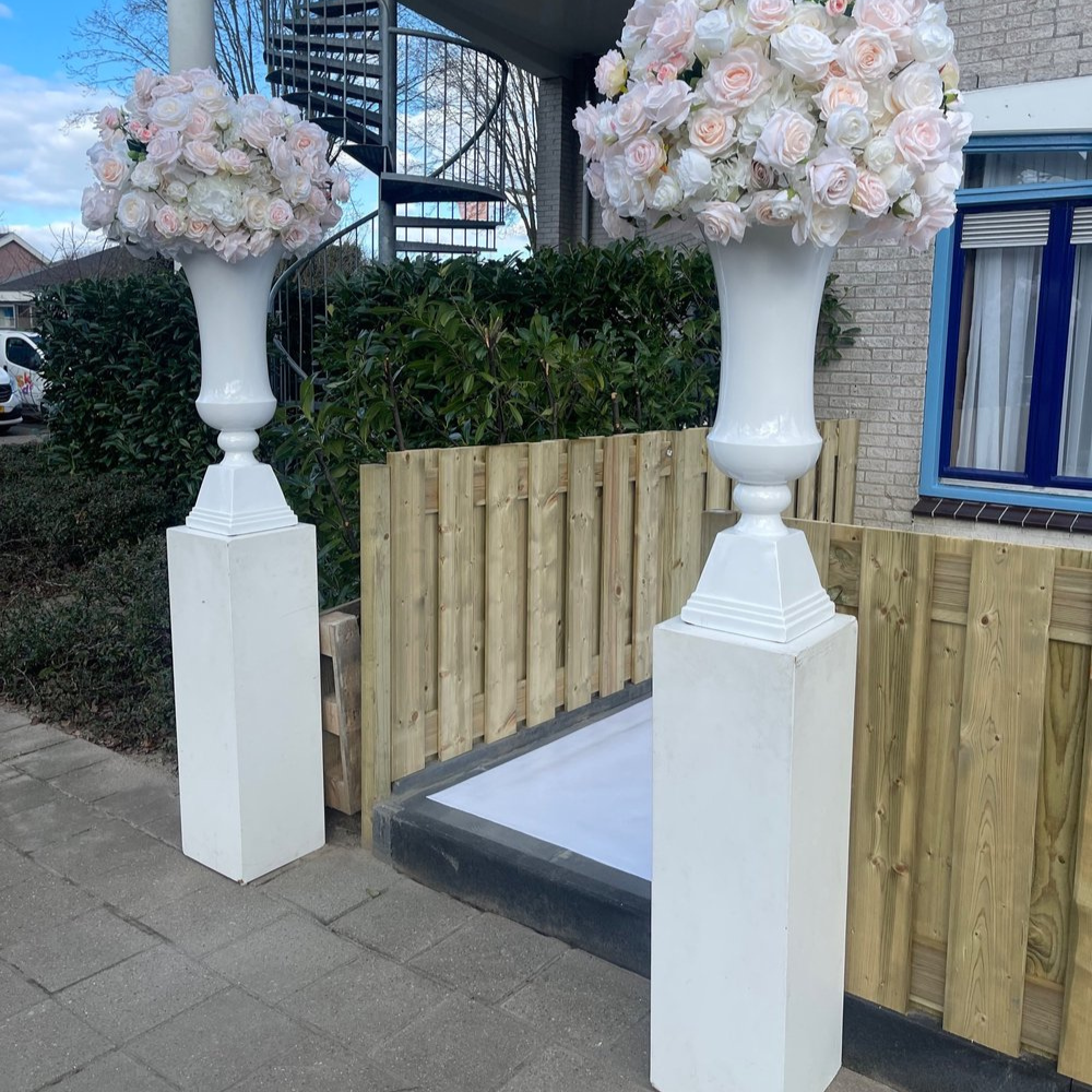 Witte vazen met roze en witte bloemen buiten