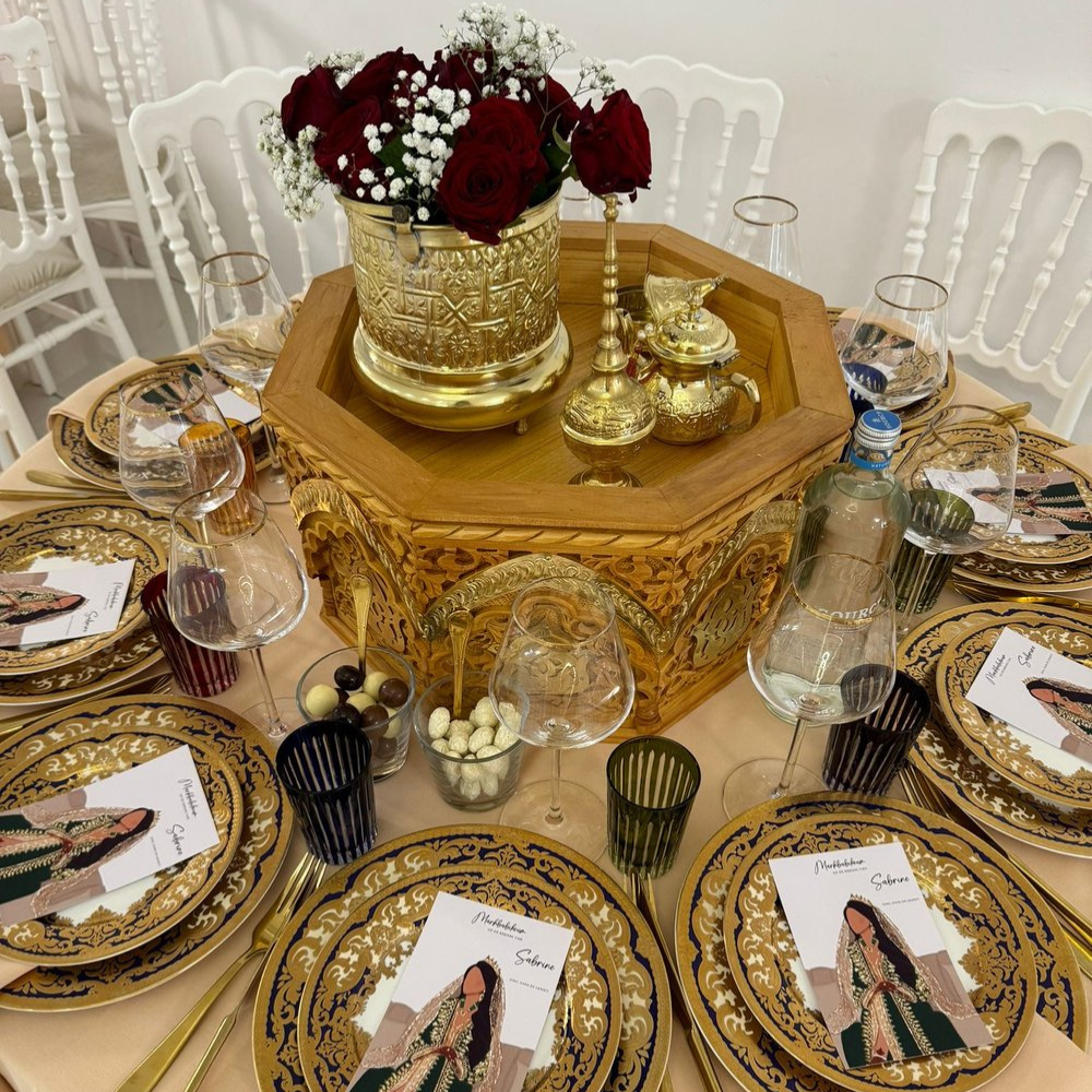 Gedekte tafel met bloemen en gedecoreerd servies.