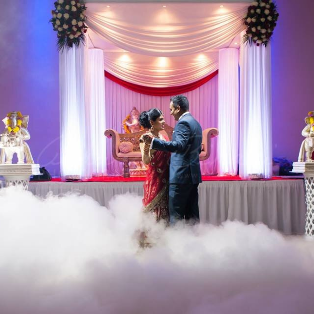 Paar dansen op bruiloft met mist en decoratie.