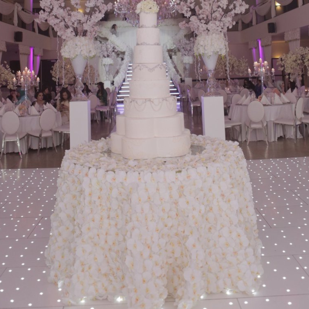 Grote witte bruidstaart in luxueuze feestzaal.