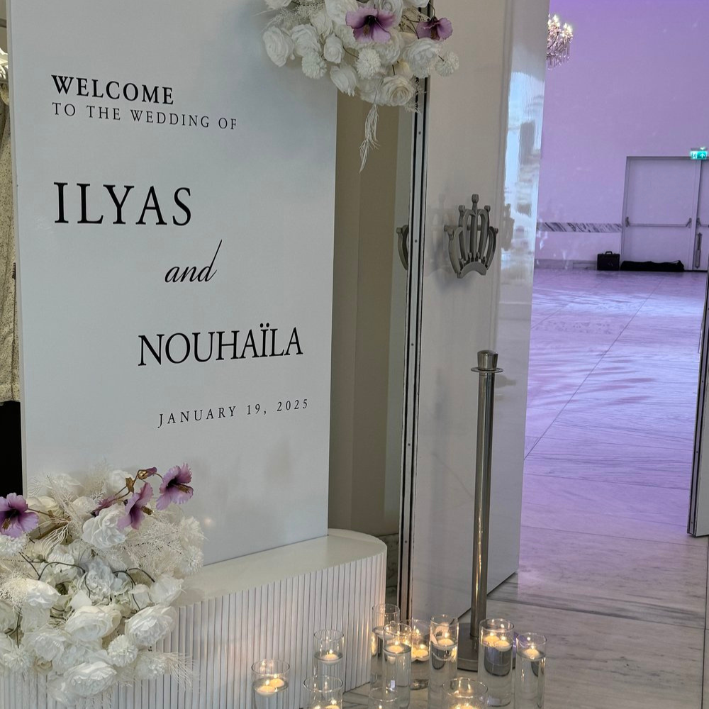 Welkomstbord bruiloft met bloemen en kaarsen decoratie.