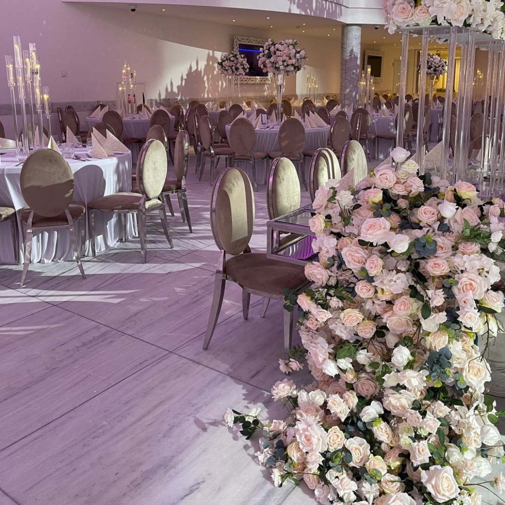 Elegante bruiloftszaal met tafeldecoraties en bloemenarrangementen.