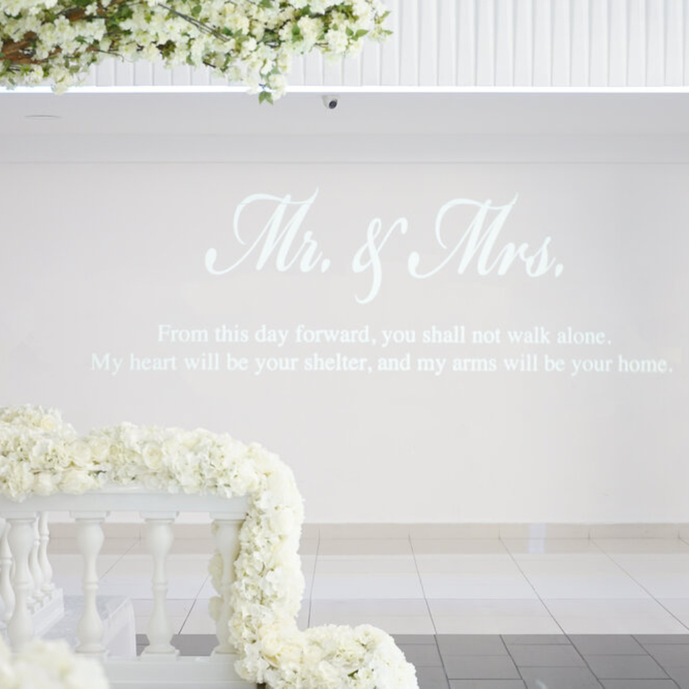 Bruiloft decor met bloemen en romantische tekst.