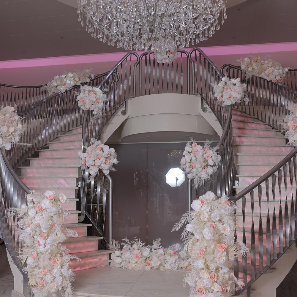 Dubbele trap met bloemen en kroonluchter decoratie.