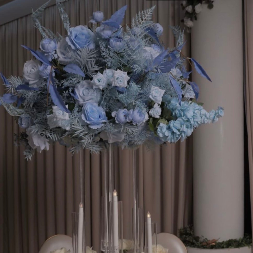 Blauwe bloemstukken op hoge standaard met kaarsen