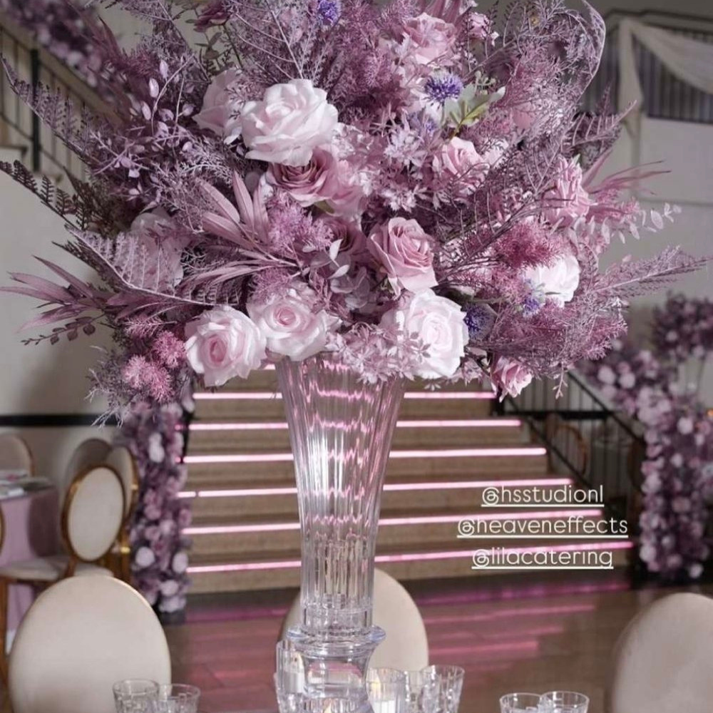 Bloemstuk met roze rozen in glazen vaas.