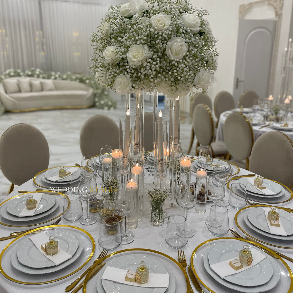 Elegante bruiloftstafel met witte bloemen en kaarsen.
