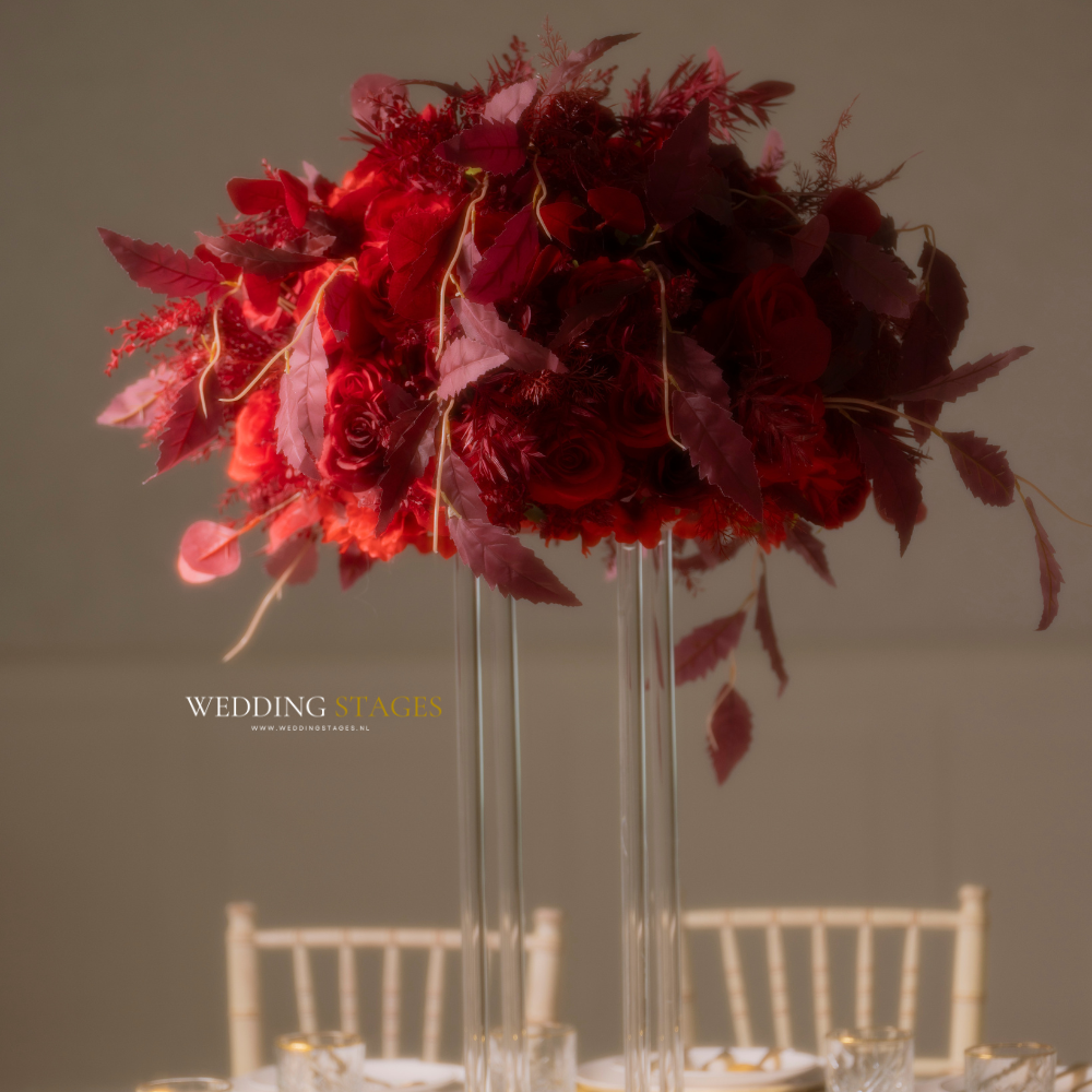 Bordeauxrode bloemen centerpiece op bruiloftstafel