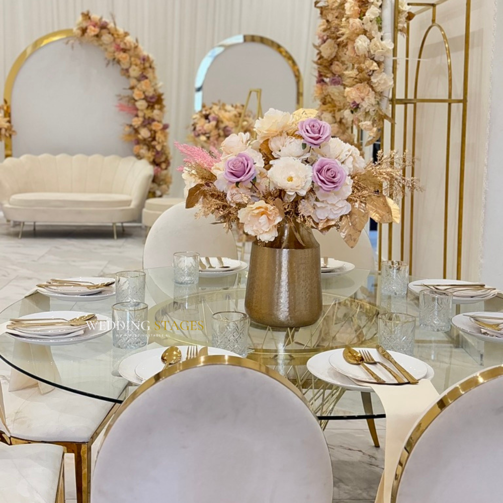 Elegante trouwdecoratie met bloemen en glazen tafel.