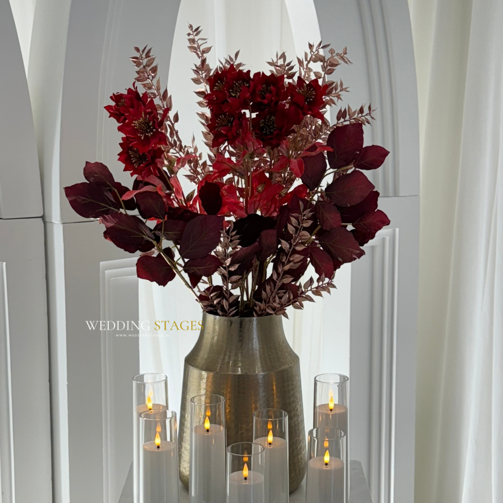 Bloemen in vaas met kaarsen op witte achtergrond.