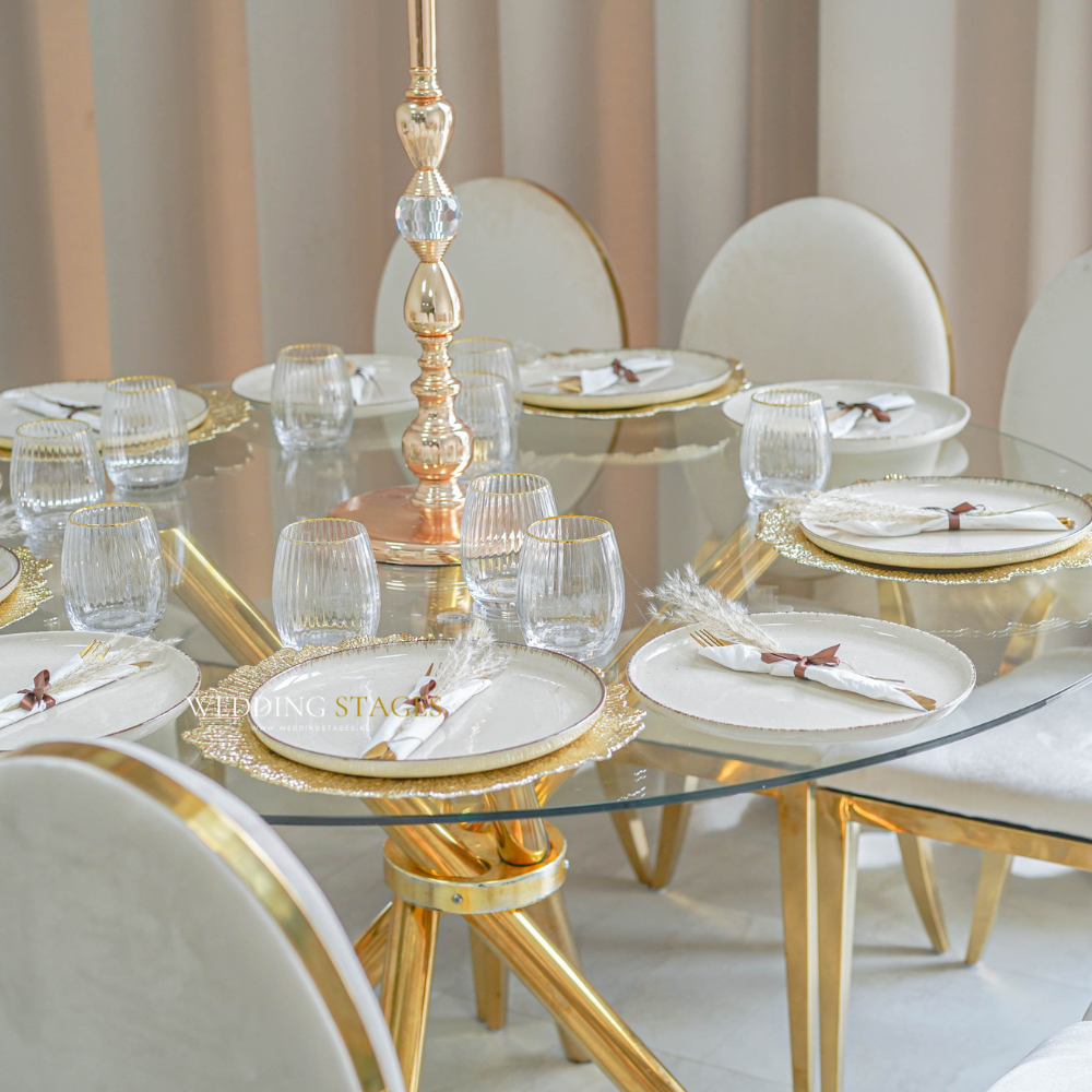 Elegante eettafel met gouden details en glazen servies.