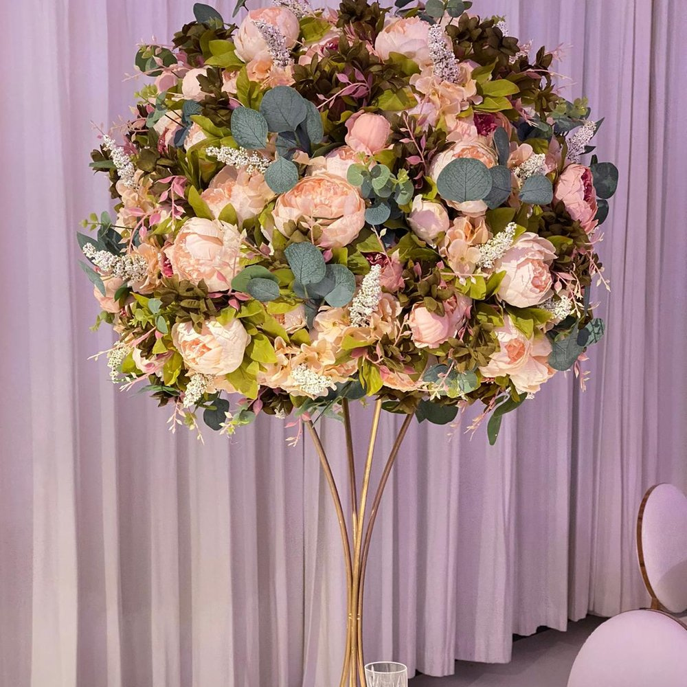 Bloemstuk met roze en groene bloemen op standaard
