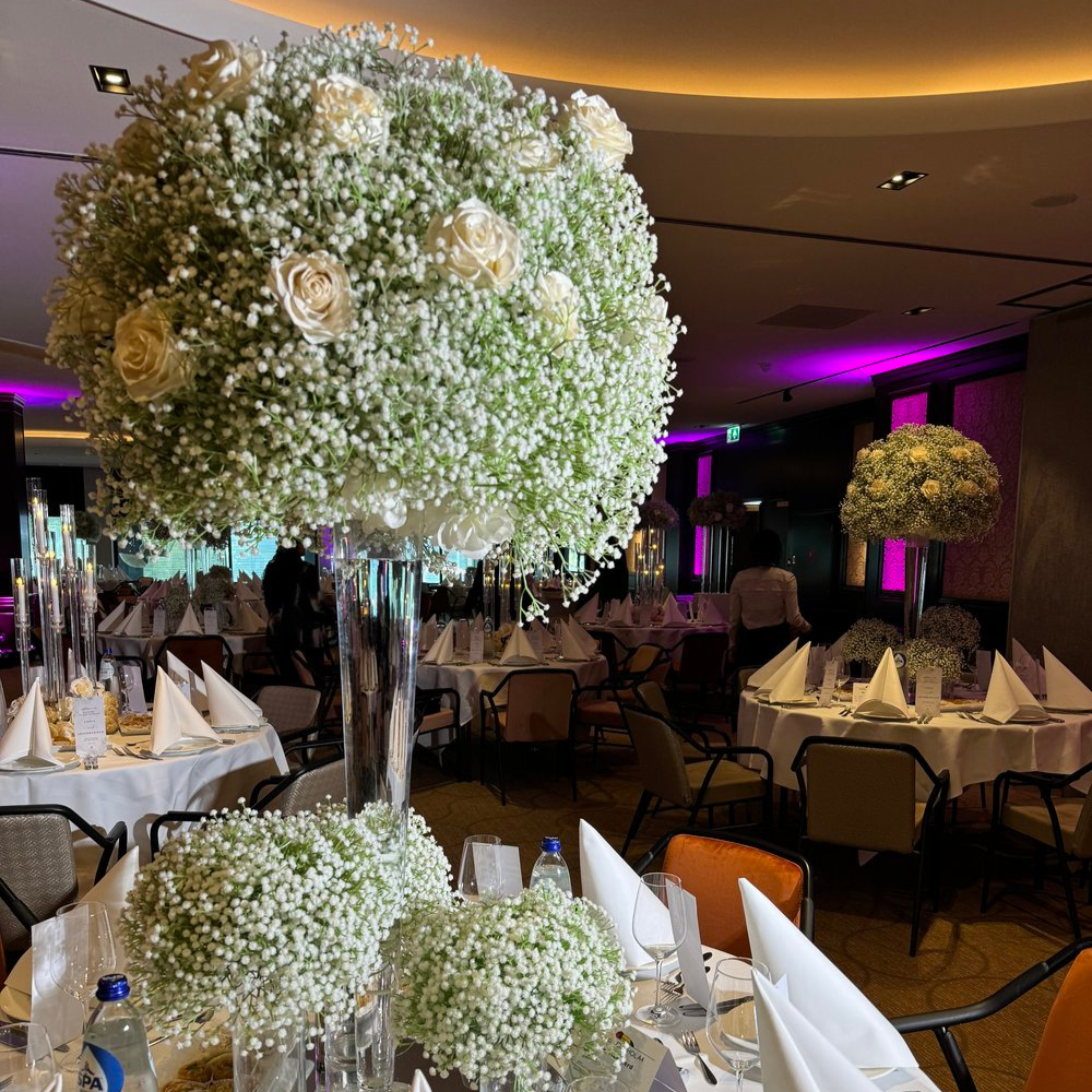 Elegante tafelbladen versierd met witte bloemen in restaurant.