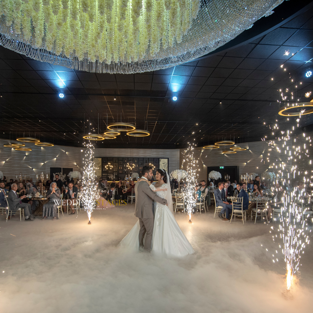 Bruiloftszaal met dansend paar en vuurwerk.