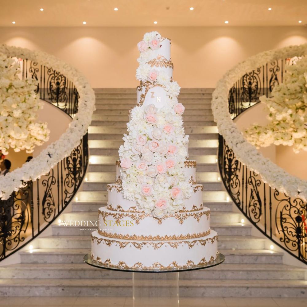 Luxe bruidstaart met bloemen en gouden accenten.
