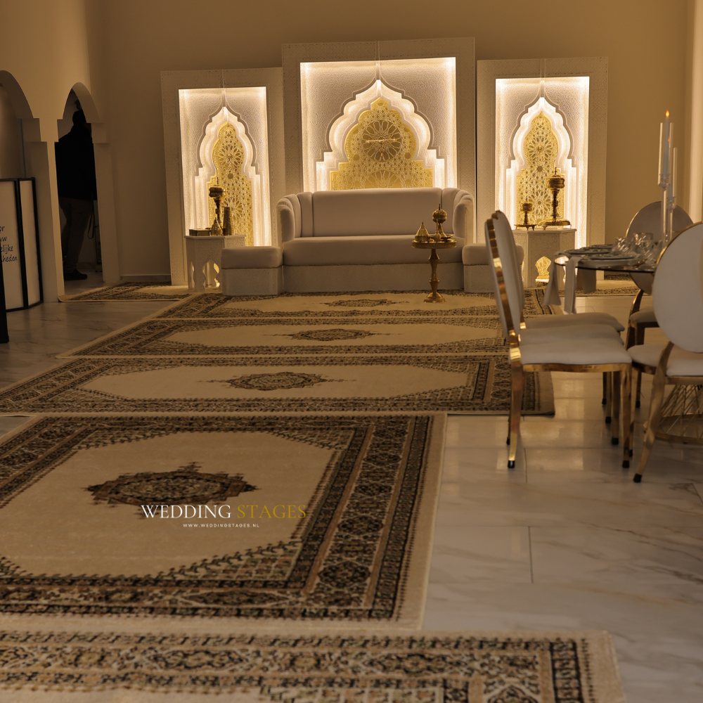 Elegant bruiloftsdecor met traditionele tapijten en zithoek.